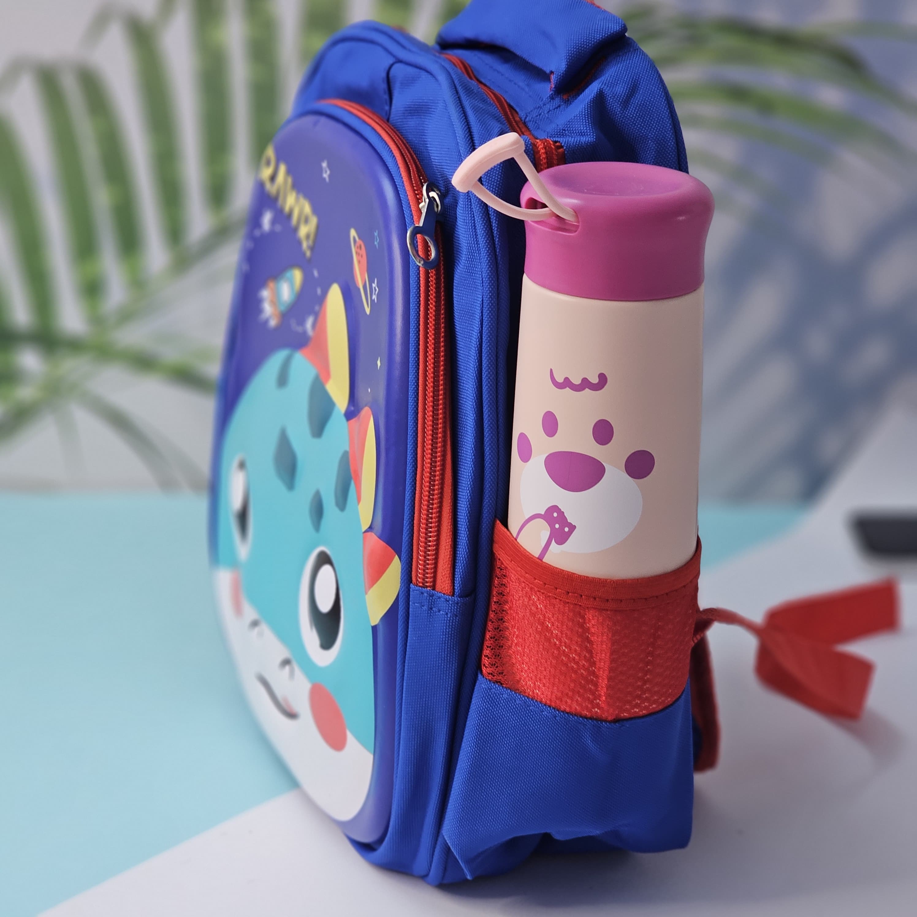 "Close-up of a Usmile Toys children's cartoon school backpack, designed in pink with a playful unicorn character on the front panel, and a matching pink water bottle in the side mesh pocket." www.usmile.toys